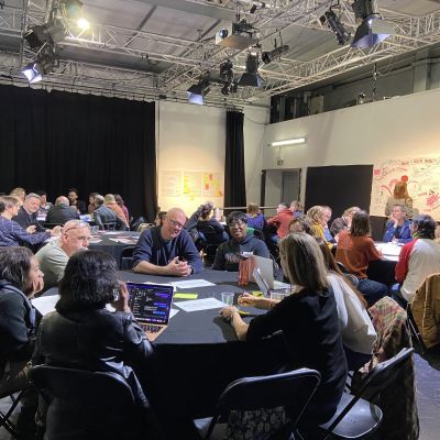 People sitting at round tables and talking and making notes